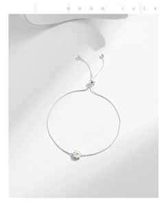 Detail of adjustable S925 silver daisy bracelet with white enamel floral charm