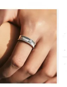 Detail of matte S925 sterling silver wide ring with a small star flower zircon