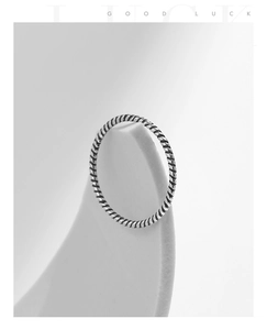 Macro view of minimalist s925 silver twisted rope ring detail on white geometric stand