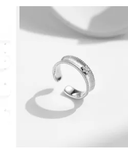 Detail of matte silver open ring with beaded edges and a small zircon flower motif