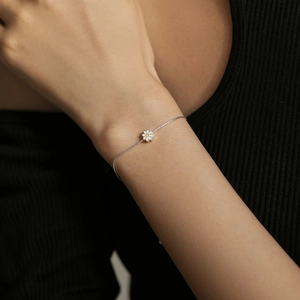 Minimalist S925 sterling silver daisy bracelet with yellow enamel on a female wrist