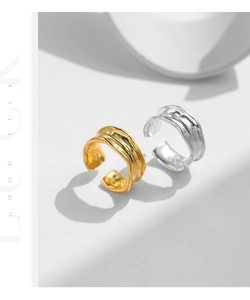 Detail of S925 silver wide open rings with irregular lava texture in gold and silver