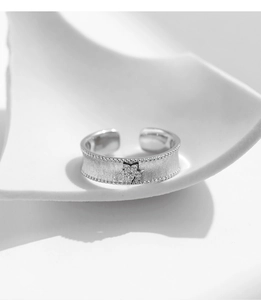 Macro detail of S925 sterling silver matte ring with star-shaped zircon and beaded edges