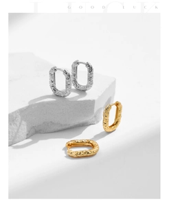 Detail of S925 sterling silver hoop earrings with hammered texture in gold and silver