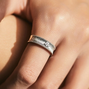 S925 sterling silver matte floral ring with beaded edges and sparkling center stone