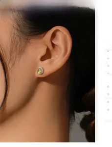 Close-up of a silver halo stud earring with a square yellow diamond on a model