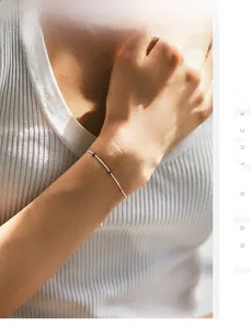 Macro shot of minimalist silver bead bracelet with colorful accents on a woman's wrist
