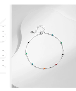 Macro shot of s925 silver beaded bracelet featuring vibrant colorful charms and tag