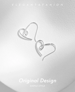 Détail des boucles d'oreilles cœur en argent S925 avec texture spirale et crochets
