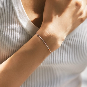 Minimalist s925 silver beaded bracelet with colorful accents worn on woman's wrist