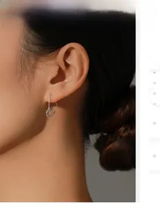 Détail de la boucle d'oreille cœur en argent s925 avec texture torsadée sur l'oreille