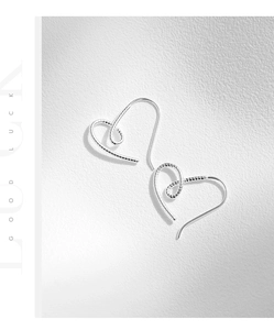 Détails de boucles d'oreilles cœur en argent avec motifs en spirale et fils texturés