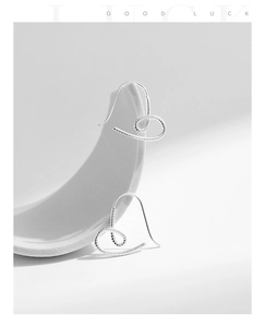 Détail de boucles d'oreilles cœur en argent s925 avec texture spirale artistique
