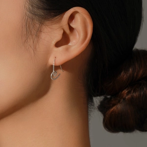 Élégantes boucles d'oreilles cœur en argent s925 avec design torsadé portées par un mannequin