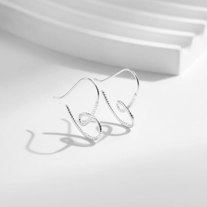 Boucles d'oreilles cœur minimalistes en argent sterling S925 sur fond blanc épuré