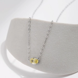 Elegante collana in argento s925 con pendente ovale in gemma gialla su sfondo bianco