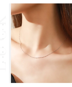 Primer plano de una cadena minimalista de plata s925 brillante en el cuello del modelo