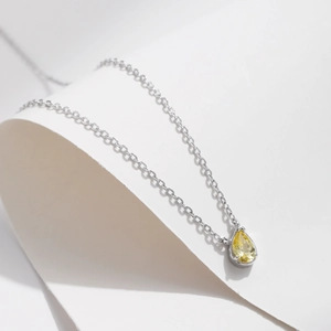 Elegant s925 silver necklace with pear-cut yellow cubic zirconia on minimalist white backdrop
