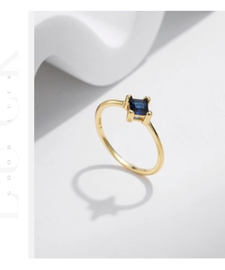 Detailed macro of S925 silver gold ring with a square blue gemstone and hallmark