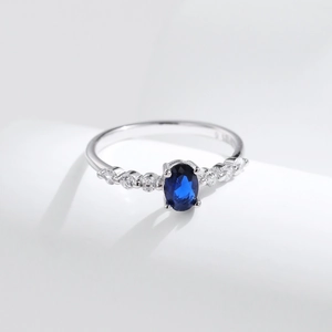 S925 sterling silver ring featuring oval blue sapphire and pavé-set side diamonds