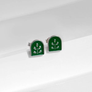S925 silver arch earrings with green enamel plant motif on white minimalist stand
