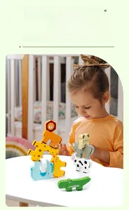 Close-up of child playing with animal wooden balancing blocks on white table