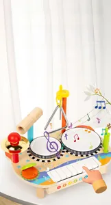 Detail view of wooden music activity station with keyboard, drums, cymbal, and triangle