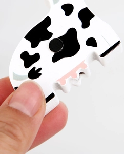 Close-up of cow pattern wooden magnetic puzzle piece with a strong round magnet back