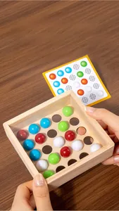 Detailed view of child's hands playing with wooden logic puzzle and colorful marbles