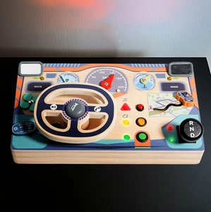 Close-up of wooden Montessori busy board featuring a steering wheel and gear shifter