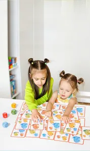 Close-up of children playing dinosaur card game with colorful dice for brain development