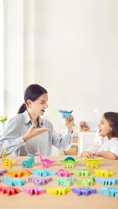 Close-up of mother and child playing with colorful wooden dinosaur alphabet puzzle pieces