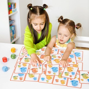 Children's dinosaur card game set with colorful dice for educational family table play