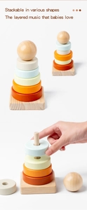 Detailed view of hand stacking colorful wooden rings on a solid timber base toy