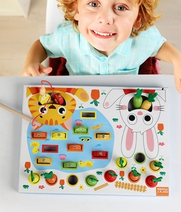 Gros plan d'un enfant jouant au jeu de pêche magnétique et de récolte de carottes