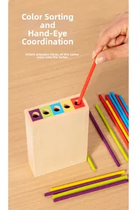 Close-up of hand inserting a red wooden stick into the Montessori educational toy base