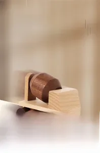 Detail of wooden cement mixer toy showing natural wood grain and rotating drum