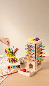 Close-up of hand placing colorful wooden sticks into the educational balancing tower toy