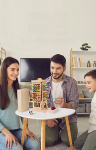 Family playing wooden 3-in-1 strategy game with colorful sticks and educational ball drop