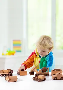 Kid playing with a natural wooden construction toy truck set in a bright room