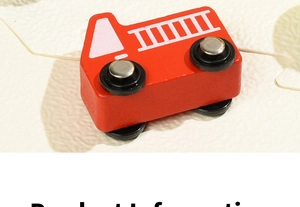 Detail of red wooden fire truck toy with white ladder patterns and black wheels
