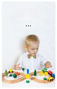 Detail of child assembling modular wooden train track set with colorful toy vehicles