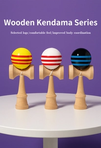 Three striped wooden Kendama toys with glossy finish displayed on a white round table