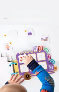 Détail d'un livre Montessori montrant un enfant manipulant des cartes de nombres