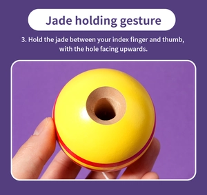 Detail of yellow Kendama ball with red stripes and top hole for skill coordination