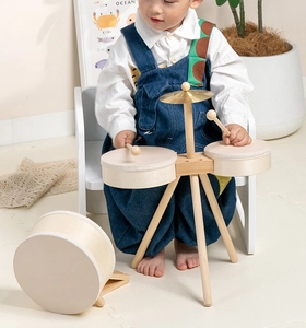 Detailed view of natural wooden drum set with cymbals and drumsticks for toddlers
