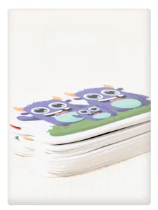 Close-up of thick, durable white cardboard early learning cards with cute monster designs