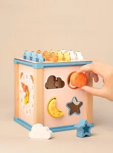 Gros plan d'un cube d'activités Montessori en bois avec insertion d'un bloc soleil