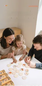 Close-up of parents and child playing with wooden animal memory matching game set