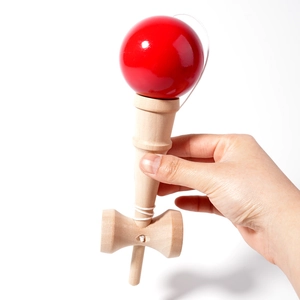 Classic wooden Kendama toy with a polished bright red ball and natural wood handle